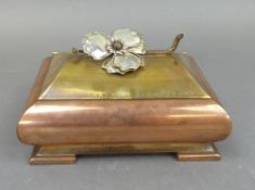 A Copper and Brass Footed Musical Box Decorated With a Metal Tone Flower. Measures:- D 14cm x W 18cm