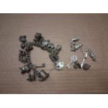 Sterling silver charm bracelet together with extra loose sterling silver charms, combined 117.2g.