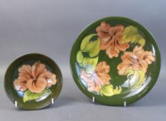 Walter Moorcroft bowls in the Coral Hibiscus pattern on green ground. (Largest Dia: 24.5cm) (2)