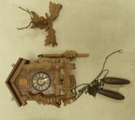 Traditional Black Forest hunting lodge style cuckoo clock featuring carved wood bird and leaf
