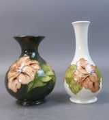 Moorcroft vases in the Coral Hibiscus pattern on green and white grounds. (Tallest: 16cm) (2)