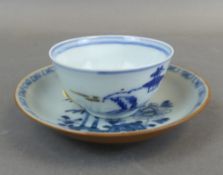 A Chinese 'Nanking Cargo' Tea bowl & saucer, decorated in typical Blue & White colours, hairline
