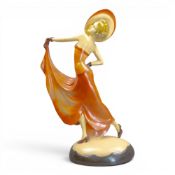 Art Deco style chalkware figurine depicting a stylised lady in a flowing orange dress and large hat,