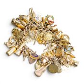 9ct gold heavy charm bracelet, containing over 70 charms, one not gold charm noted and several