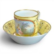 A late 18th or early 19th Sévres porcelain coffee can and deep-welled saucer, hand-painted with a