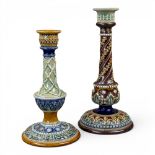 Two Doulton Lambeth candlesticks of varying sizes and designs, both with typical embossed designs,
