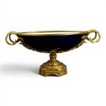 An oval porcelain serving bowl with cobalt exterior, with ornate gilt metal mounts, handle to handle