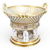 Continental twin handled reticulated centre basket raised on Putti supports and a stepped base,