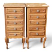 A pair of French Louis XV style oak tallboy cabinets, featuring carved drawer fronts and scrollwork.