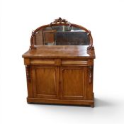 Victorian-style mahogany chiffonier, featuring arch mirror back, adorned with ornate detailing. (