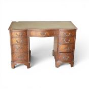 Mahogany serpentine knee-hole pedestal desk with green leather writing surface, together with swan-