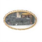 An Oval Shaped wall Mirror in a gilt effect metal frame, total length 66cm.