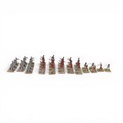 A collection of early flat tin toy soldiers, hand-painted and mounted on strips of cardboard strips.