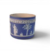 A Blue Dip Wedgwood Jasper ware jardiniere on Three white feet, typically decorated with white
