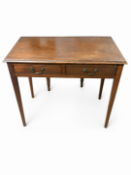 A wooden two drawer console table with brass drop-pull handles and slender, tapered legs. 74cm H x