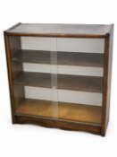 A mid-20th-century wooden bookcase with dual sliding glass doors and internal shelving. 85c