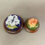 Two Moorcroft Hibiscus pattern paperweights, diameter of largest 10.5cm (2).
