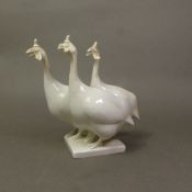 A Meissen figural group of three guinea fowl, Blanc de Chine, designed by Peter Strang in 1964, blue