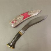 A white metal mounted Ceremonial Gurkha Kukri knife, in red velvet covered sheath, ornately