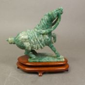 A carved green stone model of a Chinese war horse in the Chinese archaistic style, the marbled stone
