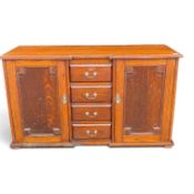 Oak sideboard with 4 central drawers, flanked by cupboards with internal shelves and brass