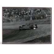 Framed black and white photograph depicting Gilles Villeneuve, driving his Ferrari with a