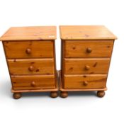 A pair of pine 3 drawer bedside cabinets on bun feet. (H: 60cm x W: 45cm)