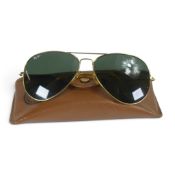 A vintage pair of ray ban aviators, with brown leather case.
