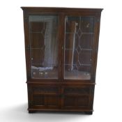 An Old Charm oak display cabinet with glass shelving, H161cm x W103cm x D38cm.