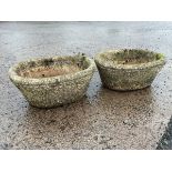 A pair of composition stone garden troughs of oval basketweave form having cushion rims. (17in) (2)