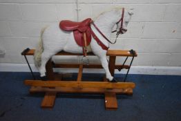 PEGASUS TOYS, A WHITE ROCKING HORSE, with a red staddle, raised on a pine frame, width 138cm x depth