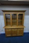 A MARKS AND SPENCER HOME LIGHT OAK DRESSER, the double glazed doors enclosing two glass shelves,