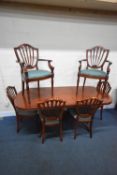 A REPRODUCTION OVAL EXTENDING DINING TABLE, with a single fold out leaf, raised on four splayed legs