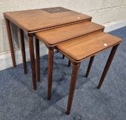 A MID-CENTURY DANISH TEAK NEST OF THREE TABLES, the largest table with a tiled sections to the