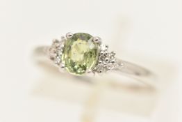 AN 18CT WHITE GOLD GEM SET RING, set with a light green oval cut stone, flanked with small single
