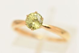 A YELLOW METAL GEM SET RING, set with a circular green stone assessed as Sphene, stamped 18k, ring