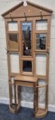 A PINE HALL STAND, with a broken arch pediment, four mirror plates, five coat/ hat hooks, a hinged