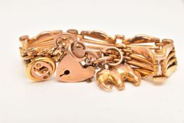 A YELLOW METAL GATE BRACELET, fitted with a heart padlock clasp, also fitted with an elephant