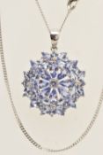 A 9CT WHITE GOLD TANZANITE CLUSTER PENDANT, approximate width 22.5mm, suspended from a fine curb