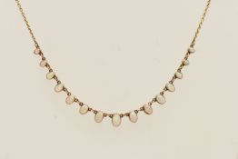 AN EARLY 20TH CENTURY YELLOW METAL AND OPAL FRINGE NECKLACE, comprised of fifteen oval opals in a