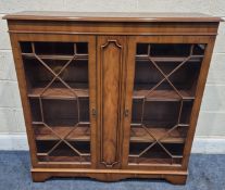 A REPRODUCTION YEW WOOD BOOKCASE, the double glazed doors enclosing three adjustable shelves,