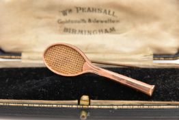 AN EARLY 20TH CENTURY ROSE METAL TENNIS RACKET BROOCH, approximate length 51mm,  personalised
