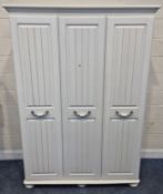 A MODERN WHITE TRIPLE DOOR WARDROBE, with bun feet, width 144cm x depth 48cm x height 197cm,