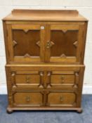 AN OAK GEOMETRIC PATTERN TWO-DOOR CUPBOARD, over two drawers, width 98cm x depth 58cm x height