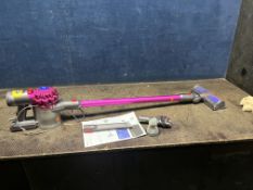 A DYSON V7 MOTORHEAD CORDLESS VACUUM CLEANER with charger, two accessories and manual, along with
