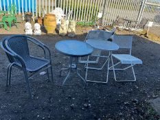 A GLASS-TOPPED GARDEN TABLE with two matching arm chairs, 60cm in diameter and a folding metal table