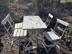 A METAL FOLDING TABLE AND FOUR MATCHING CHAIRS with a wooden top, seats and backs, table width