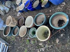 ELEVEN GREEN OR BROWN GLAZED PLANT POTS, of various shapes and sizes, the largest being 44cm high.