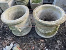 A PAIR OF CONCRETE PLANTERS with cherub figural detail to sides, 42cm in diameter