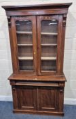 A VICTORIAN MAHOGANY BOOKCASE, the double glass doors enclosing three shelves, atop a base with a